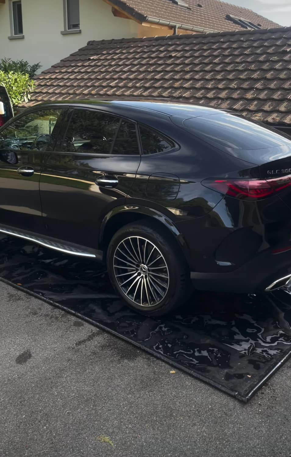 Mercedes GLC noire fraîchement lavée par Rozan devant un domicile